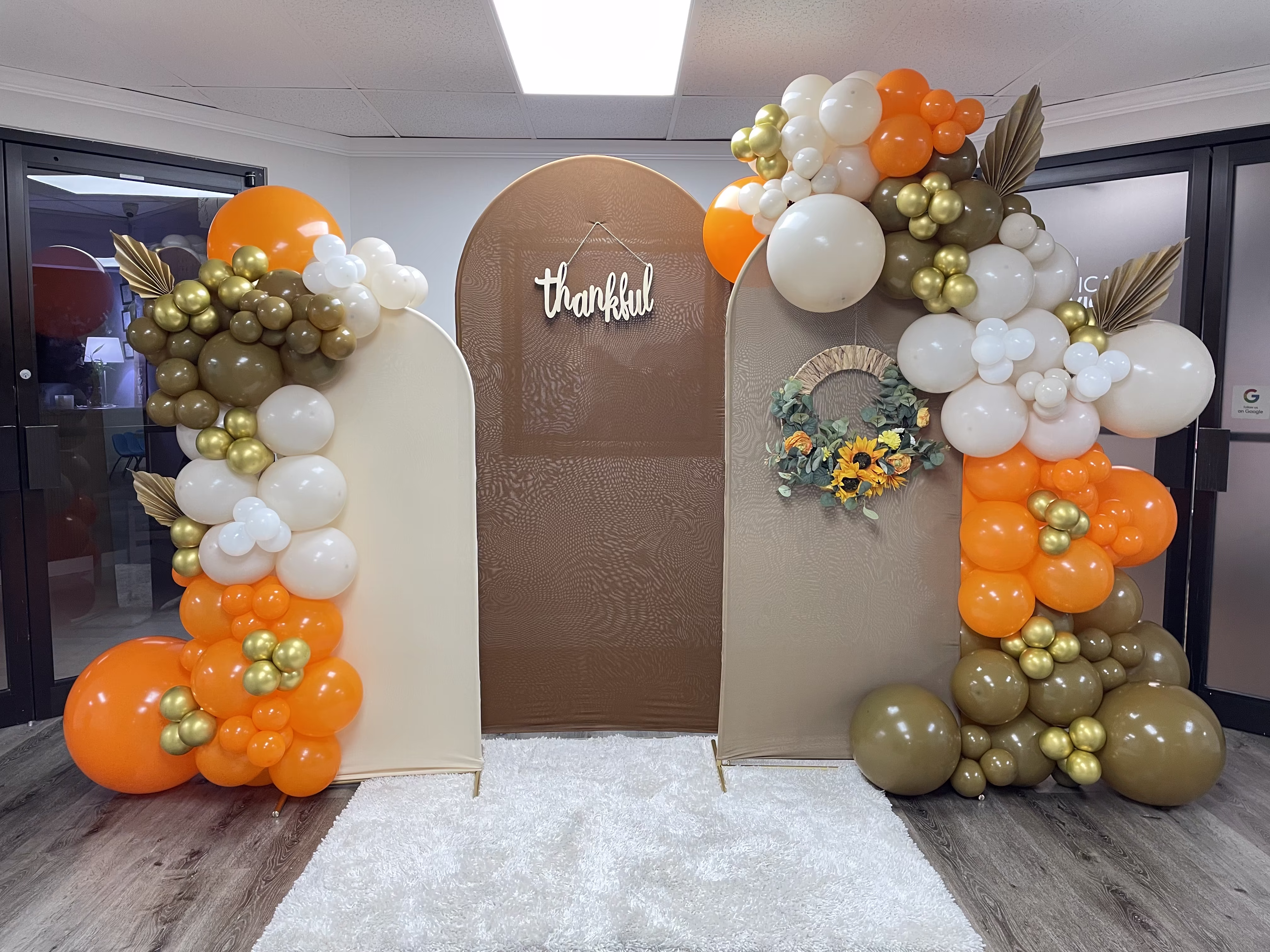 Montaje completo con tres arcos en tonos otoñales y guirnaldas de globos