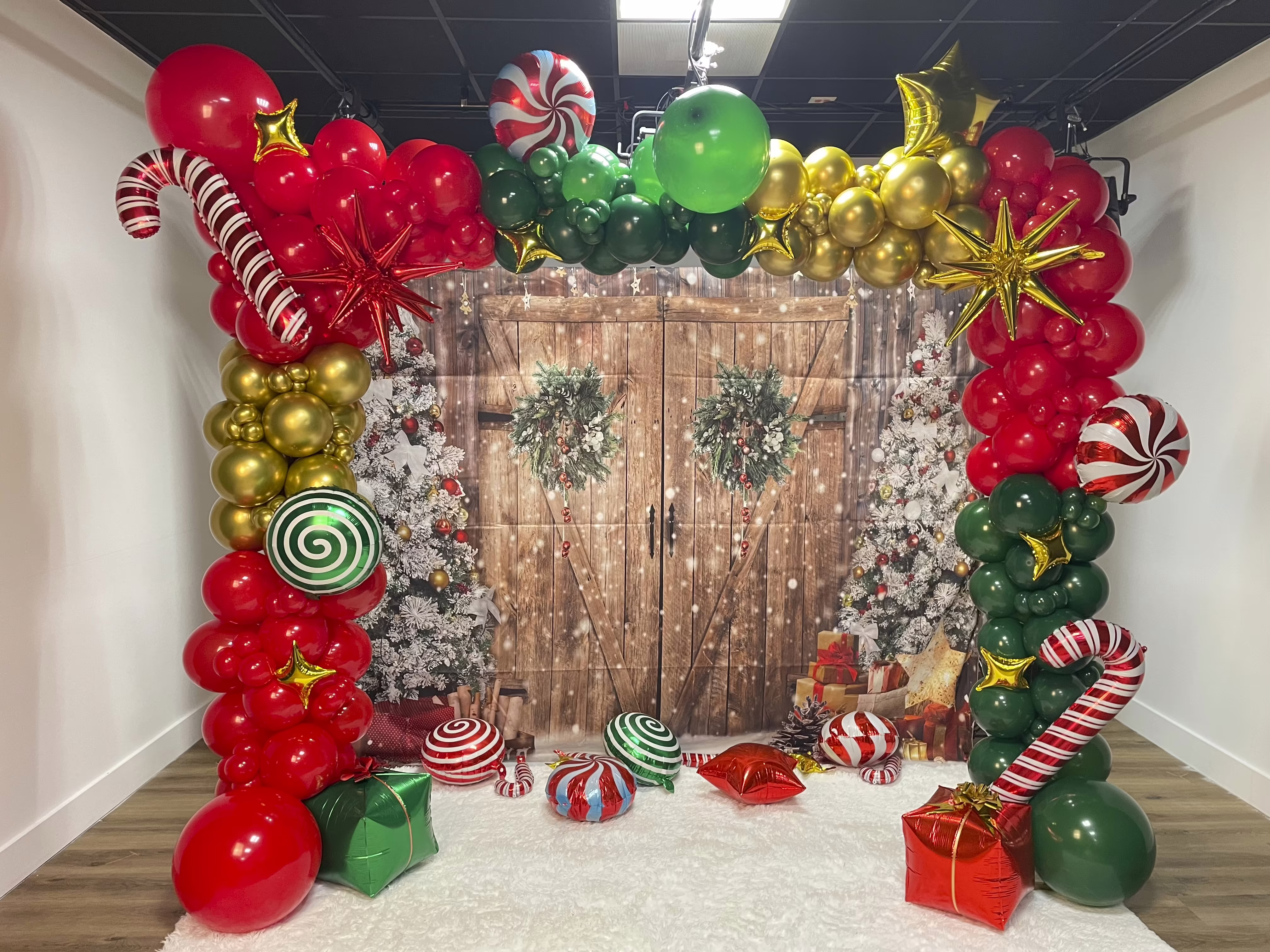 Decoración navideña con globos de colores vibrantes, bastones de caramelo y guirnalda festiva
