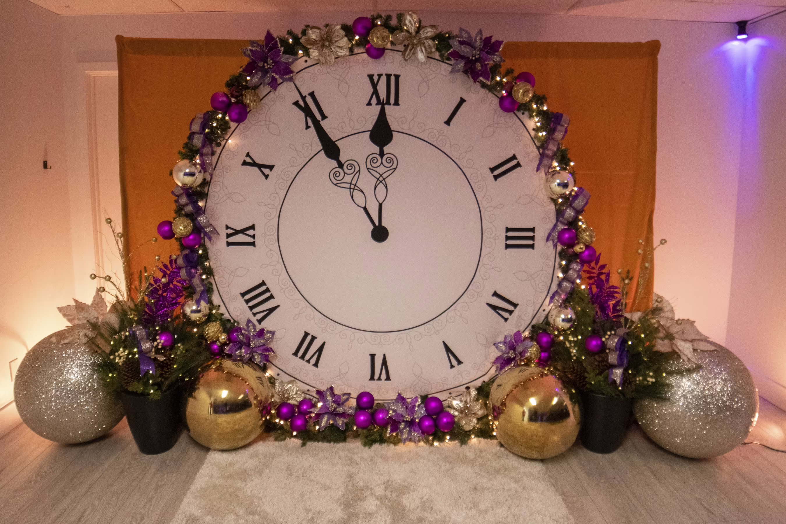 Backdrop de reloj romano gigante con arco floral y globos dorados para fiesta de fin de año